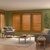 Lifestyle room scene of a transitional livingroom featuring the premium wood shutters in the golden oak color.