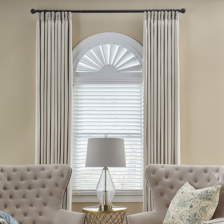 2 Inch Classic Faux Wood Blinds paired with the composite wood arch and the easy classic pleat drapery. Blind Color: White P630; Arch Color: True White 4196; Drapery Color: Athena Corn Silk 996