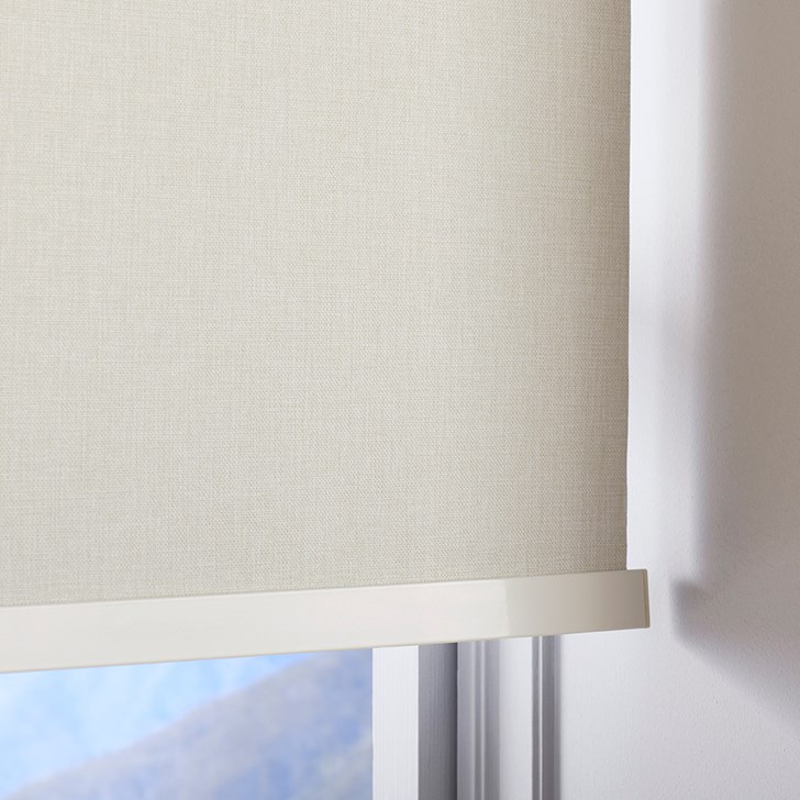 The Motorized Blackout Roller Shades in the Catania Off-White color with the Fabric Wrapped 4in. Cornice.